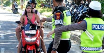 Polantas memberhentikan pengendara karena melanggar lalulintas