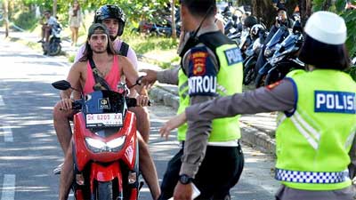 Polantas memberhentikan pengendara karena melanggar lalulintas