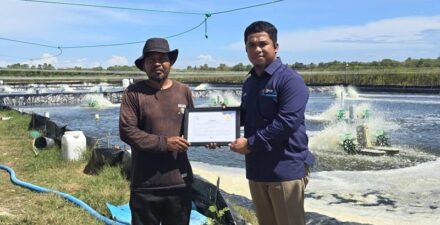 Penyerahan Renewable Energy Certificate Petugas PLN (kanan) dan kepada pemilik tambak udang vaname di Kabupaten Takalar, Sardi (kiri)