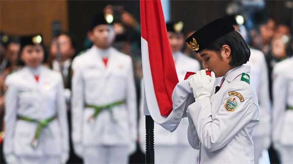 Anggota Paskibraka 2024 asal Sumatera Utara Violetha Agryka Sianturi mencium Bendera Merah-Putih dalam pengukuhan Paskibraka Tingkat Pusat 2024 di Istana Negara, Ibu Kota Nusantara (IKN), Kalimantan Timur, Selasa (13/8/2024). (dok.suara/foto; ANTARA FOTO/Sigid Kurniawan).