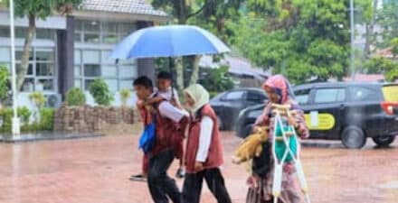 Pendamping Keluarga Harapan (PKH) saat menggendong calon siswa Sekolah Rakyat