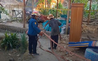 Petugas damkar Blora berupaya memadamkan api di sumur minyak ilegal.