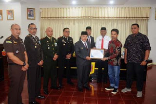 Benni Warlis, menyerahkan piagam penghargaan