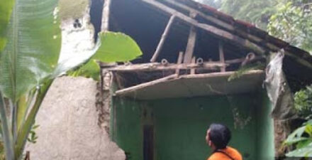 Petugas BPBD mengecek tembok rumah warga jebol imbas hujan deras