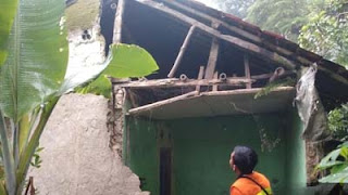 Petugas BPBD mengecek tembok rumah warga jebol imbas hujan deras