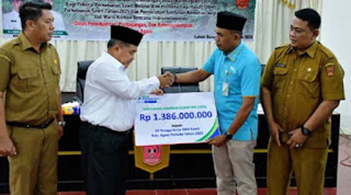 Bupati Agam, Benni Warlis didampingi Sekretaris Daerah Kabupaten Agam menyerahkan santunan.