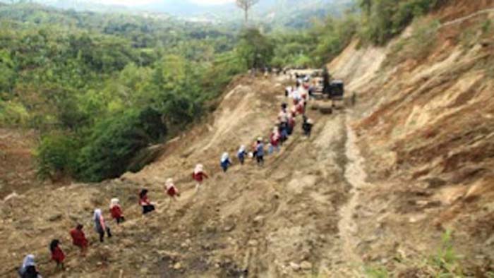 Relawan dan mahasiswa melintasi jalan Sungai Landia, Kabupaten Agam
