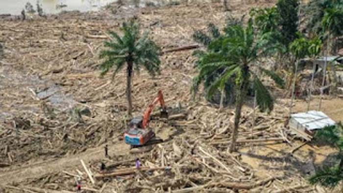 Petugas mengoperasikan eskavator untuk membersihkan jalan akses antardesa.