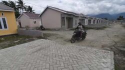 Pekerja melintas di sekitar proyek pembangunan perumahan bersubsidi di Kabupaten Sigi.