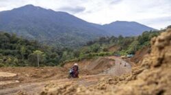 Warga melintas di Jalan Malalak yang sedang dalam tahap perbaikan di Kabupaten Agam