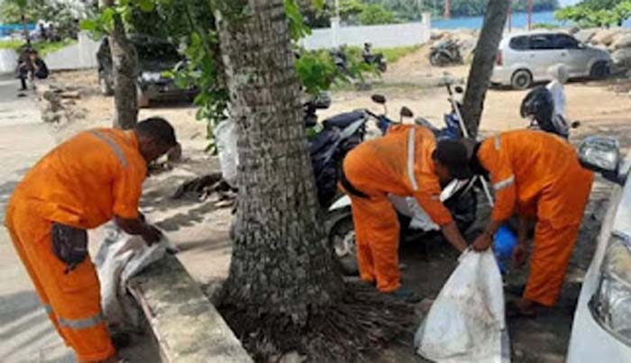 Sejumlah petugas kebersihan dari DLH Kota Padang tengah membersihkan sampah.