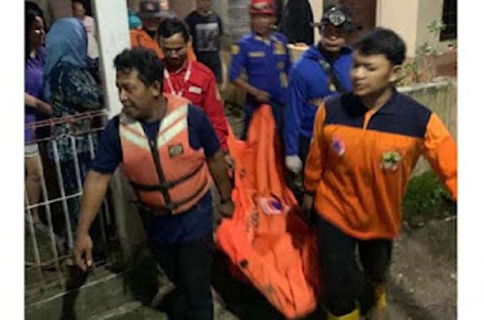 Petugas mengevakuasi mayat perempuan.