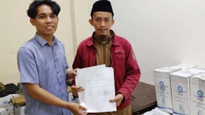 Kasi Layanan dan FPE2HU Kantor Kementerian Haji Kota Padang, Rizki Ronaldi menerima langsung distribusi air zamzam.