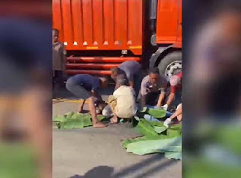 Petugas dibantu warga mengevakuasi dua pemotor yang tewas terlindas truk