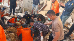 Petugas mengevakuasi korban gempa dari reruntuhan