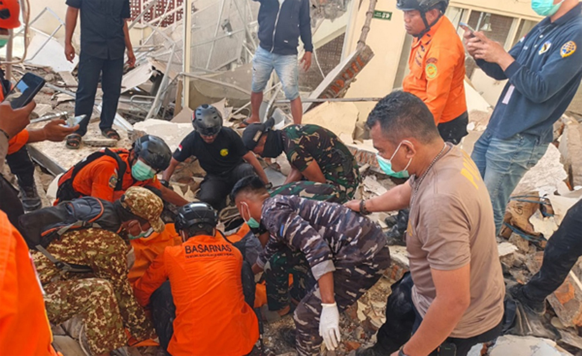 Petugas mengevakuasi korban gempa dari reruntuhan