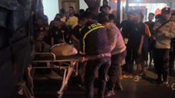 Petugas mengevakuasi pemotor yang luka parah akibat terlindas truk