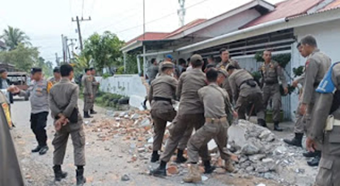 Satpol PP Kota Padang melakukan penertiban pagar rumah.